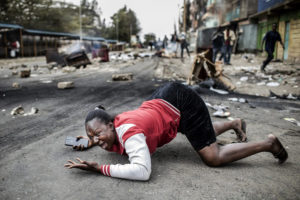 LUIS TATO/AFP | Una mujer se lamenta en el suelo el 11 de agosto después que el anuncio de los resultados electorales haya provocado disturbios entre los pro-Odinga y la policía en el suburbio de Mathare