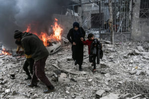 © Abdulmonam Eassa / AFP | Civils corrent per escapar dels bombardejos aeris atribuïts a forces russes i sirianes a la ciutat d'Hamouria en mans dels rebels, a la Guta, a l'est de Damasc, el 6 de gener del 2018