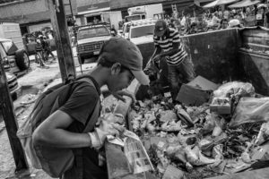 © ÁLVARO YBARRA ZAVALA | Juan Carlos, albañil aunque sin trabajo, y uno de sus hijos buscan comida entre las basuras de Caracas, en 2016