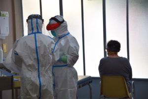 ÈLIA PONS | Dos sanitarios del centro de primaria Raval Nord de Barcelona, equipados con EPI por el coronavirus, atienden a un paciente