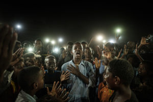 YASUYOSHI CHIBA/AFP | Un jeune homme récite une poésie de combat à Khartum, le 19 juin 2019, semaines après la chute du dictateur soudanais Omar al-Bashir (photo primée avec le World Press Photo 2020)