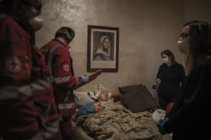 FABIO BUCCIARELLI/NEW YORK TIMES | Voluntarios de la Cruz Roja vienen a buscar a casa el 15 de marzo a Claudio Travelli, de 60 años y enfermo de la Covid, en Cenate Sotto, provincia italiana de Bérgamo
