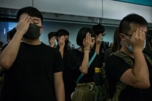 NICOLE TUNG | Estudiantes en Hong Kong se tapan el ojo derecho, el 21 de agosto de 2019, en solidaridad con la enfermera que diez días antes había perdido el ojo por un disparo de la policía