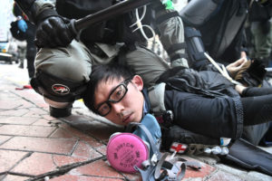 ANTHONY WALLACE/AFP | Manifestante detenido en el suelo en Hong Kong el uno de octubre de 2019, jornada del 70 aniversario de la creación de la República Popular de China