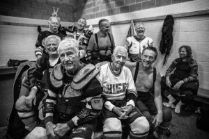 DAVID BURNETT/CONTACT PRESS IMAGES | El equipo de hockey sobre hielo de los Gray Wolves (los lobos grises) posa con Marsh Webster, jugador de 95 años (camiseta blanca), en Skaneateles, Estado de Nueva York, en septiembre de 2018