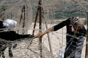 ÉRIC BOUVET : Deux femmes palestiniennes se saluent à travers les barbelés à Dhaira, à la frontière libano-israélienne, en mai 2000, après 22 ans d'occupation israélienne du Sud-Liban