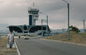 SISTER PRODUCTIONS | Uno de los personajes, un niño armenio, en el film <em>Si le vent tombe</em>, de Nora Martirosyan, con el aeropuerto inactivo de Stepanakert de fondo