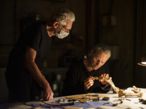 NIKOS NIKOLOPOULOS | David Cronenberg, portant un masque, et Viggo Mortensen manipulant l'exosquelette pour Les Crimes du futur sur le tournage en Grèce.