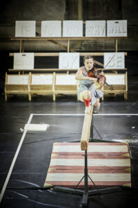 CHRISTOPHE RENAUD DE LAGE | La violinista-atleta-actriu de One Song, de Miet Warlop, en plena execució sobre la barra d'equilibris