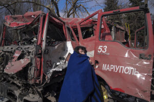 EVGENIY MALOLETKA/ASSOCIATED PRESS | Una mujer delante de un camión de bomberos destruido por tiros de obús, durante el sitio de Mariúpol por parte del ejército ruso, el pasado 10 de marzo