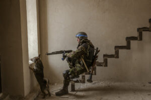 DANIEL BEREHULAK/NEW YORK TIMES/MAPS | Un perro errante que Berehulak fotografió en Irpín al lado de un combatiente ucraniano cuando estos repelían los últimos soldados rusos el 29 de marzo pasado