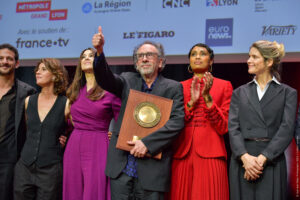 JEAN-LUC MEGE | Tim Burton, con el Premio Lumière 2022 y arropado, de izquierda a derecha, de los actores y músicos Vincent Dedienne, Irène Jacob, Monica Bellucci, Imany y Alice Taglioni