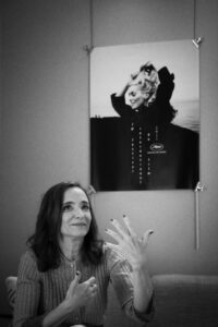 MARCO BARADA | Pendant l'interview d'Ana Torrent pour Fermer les yeux, avec l'affiche du Festival de Cannes 2023 et la silhouette de Catherine Deneuve en arrière-plan