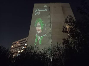 PHOTOGRAPHIE ANONYME | Le visage de Mahsa (Jina) Amini sur la façade d'un immeuble du quartier d'Ekbatan à Téhéran, avec le slogan Femme, Vie, Liberté, le 25 octobre 2022