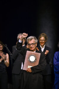 OLIVIER CHAISSIGNOLE/INSTITUT LUMIÈRE | Wim Wenders, avec le Prix Lumière 2023 dans de la cérémonie à Lyon le 20 octobre, et derrière son épouse, la photographe Donata Schmidt