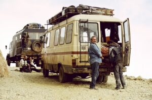 QUIM VIVES | Un momento del rodaje de <em>Sirât</em>, de Óliver Laxe, con Sergi López, los <em>travellers</em> y los camiones atravesando el Atlas
